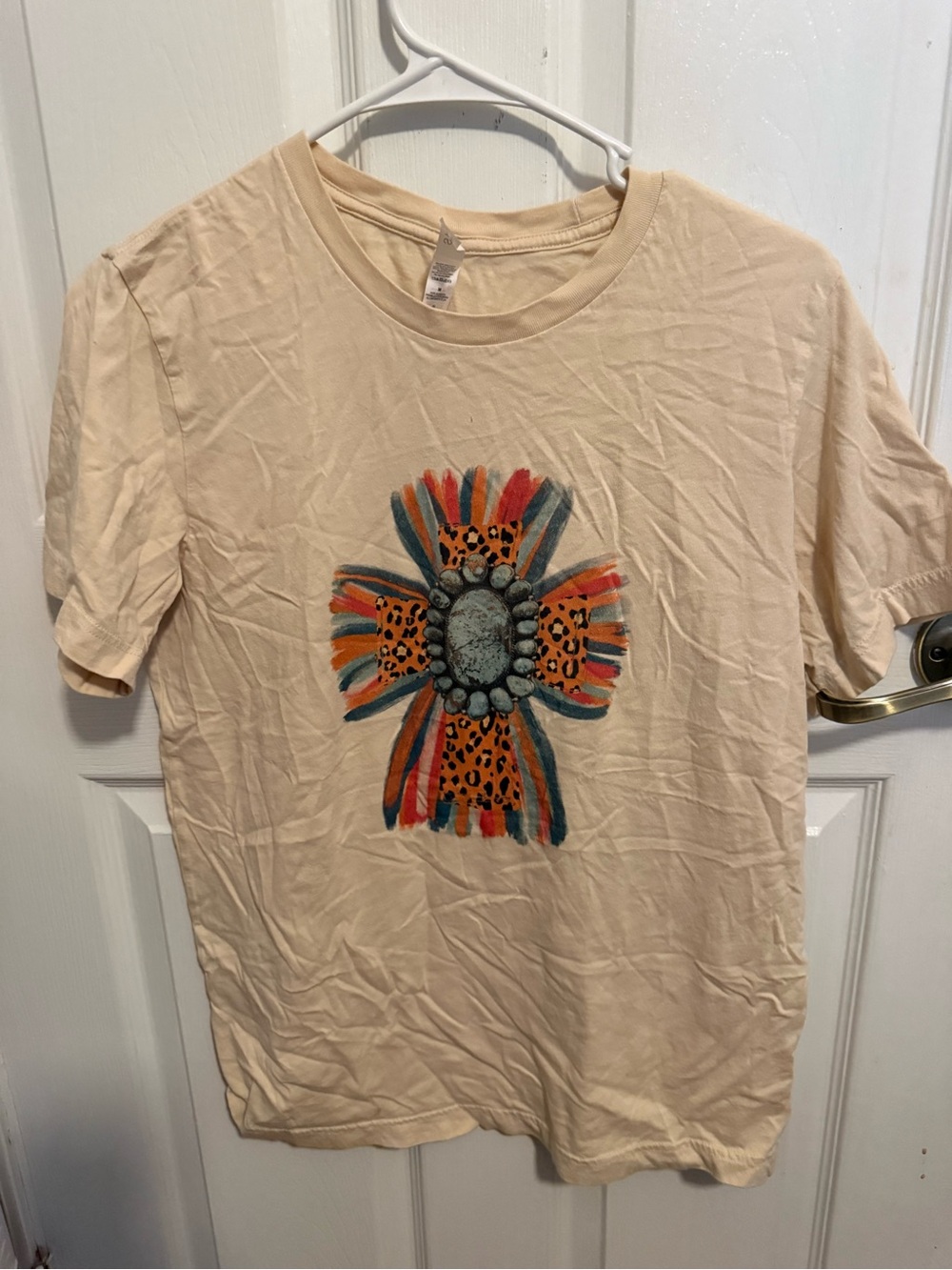 Bella+Canvas Cream Graphic Cross Tee with Orange, Teal, and Black Accents